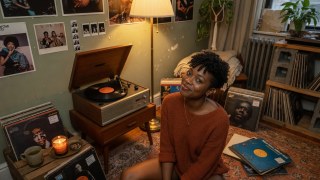 Turntable corner with records scattered and low light.